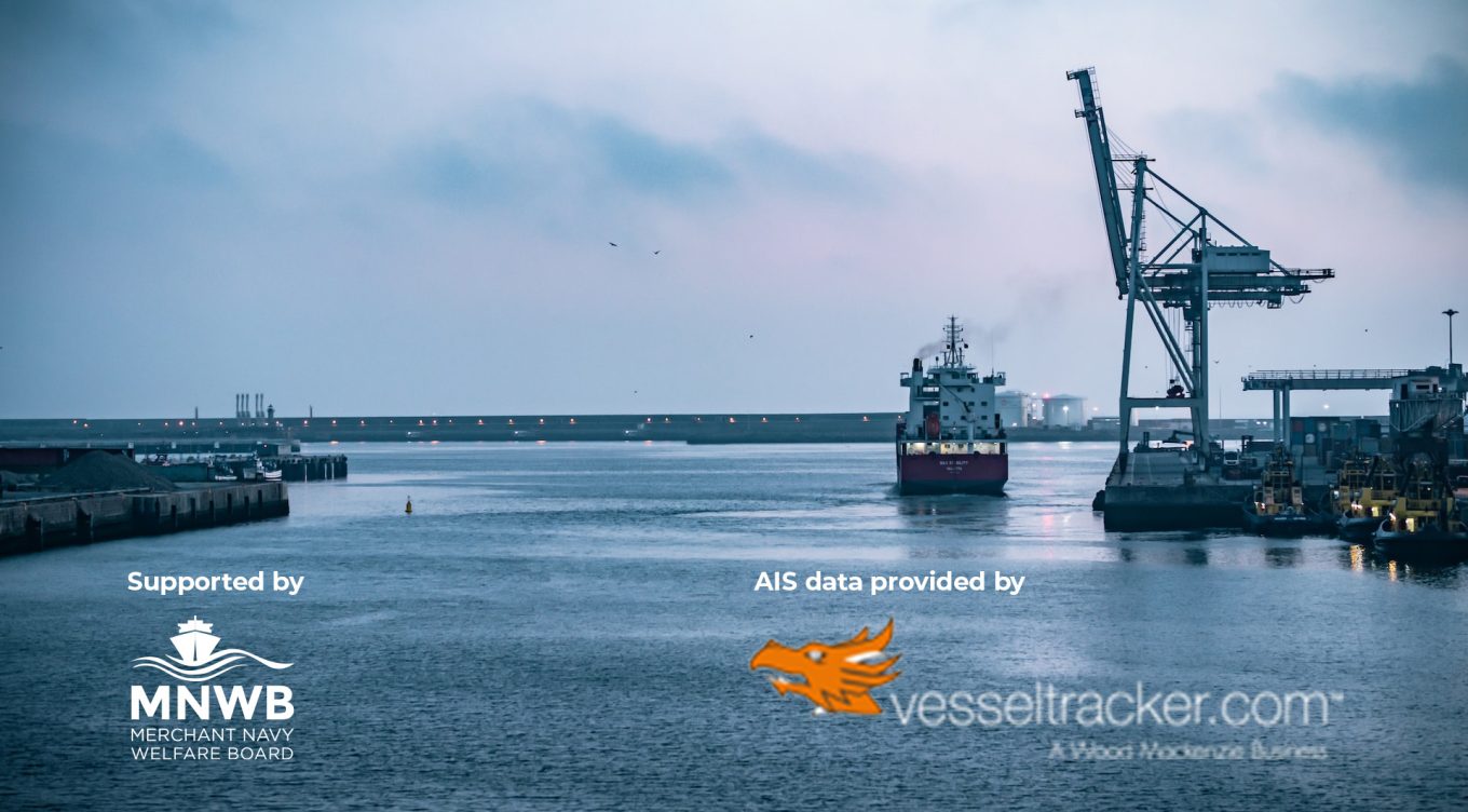 Ferry leaving a port with crane visible on the right of the frame. Early evening on calm sea.